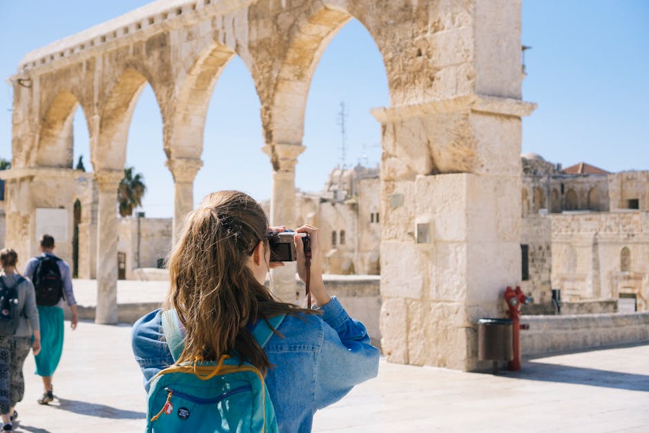 A tourist photographs the ancient stone arches in Jerusalem's Old Town