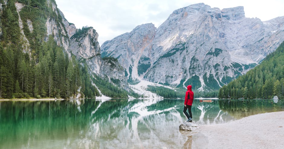 Person standing by the scenic Lake Braies with Dolomite mountains