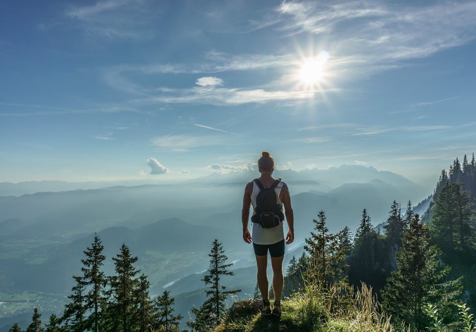 A lone hiker stands on a mountain top in Slovenia